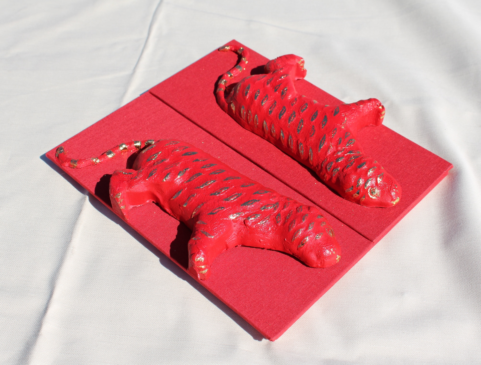 an bright red accordion book with a tiger molded on the cover