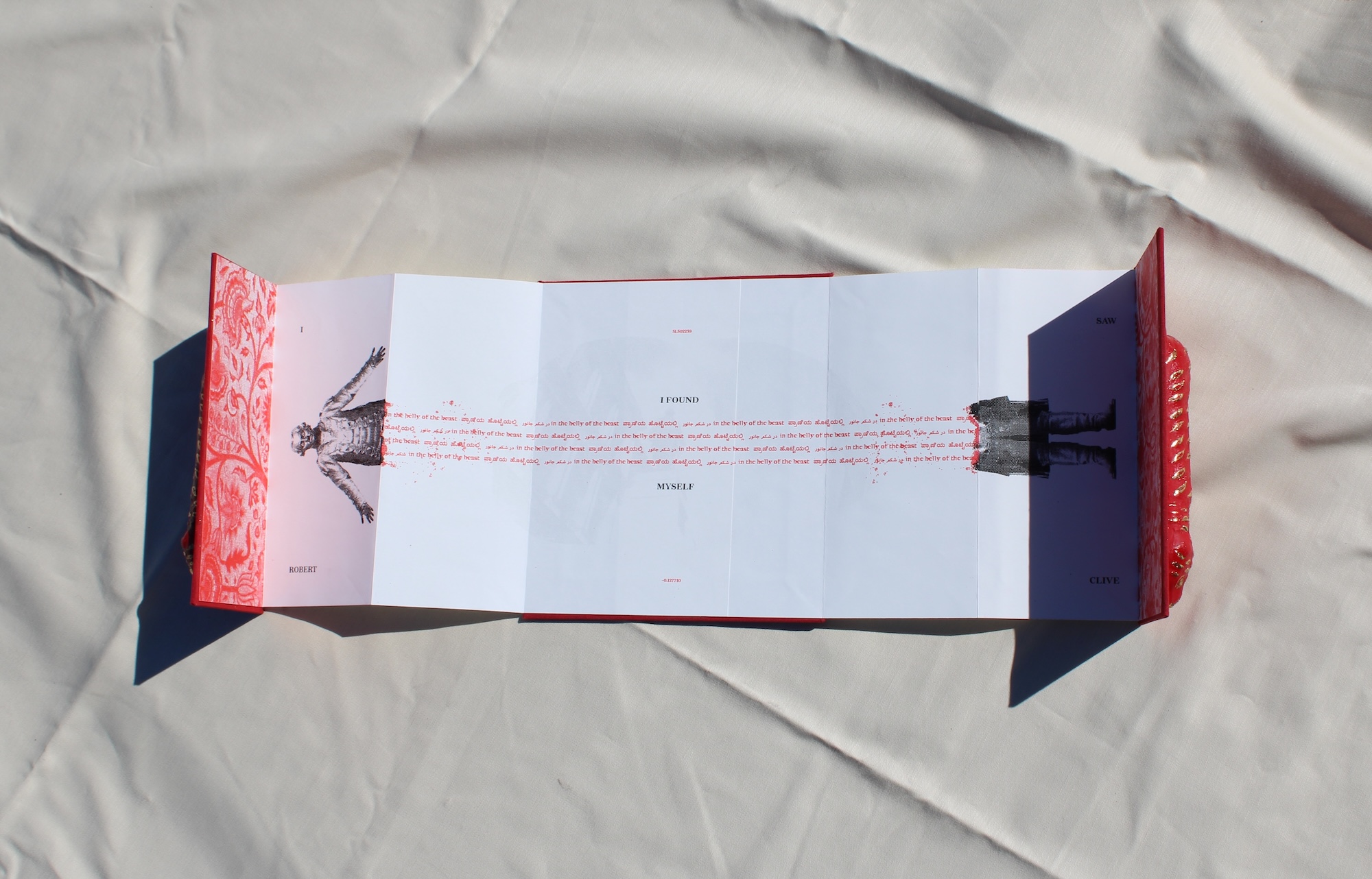 an bright red accordion book with a tiger molded on the cover. Inside the tiger's belly is Robert Clive being split in half to reveal the text 'I saw Robert Clive//I saw myself in the belly of the beast'