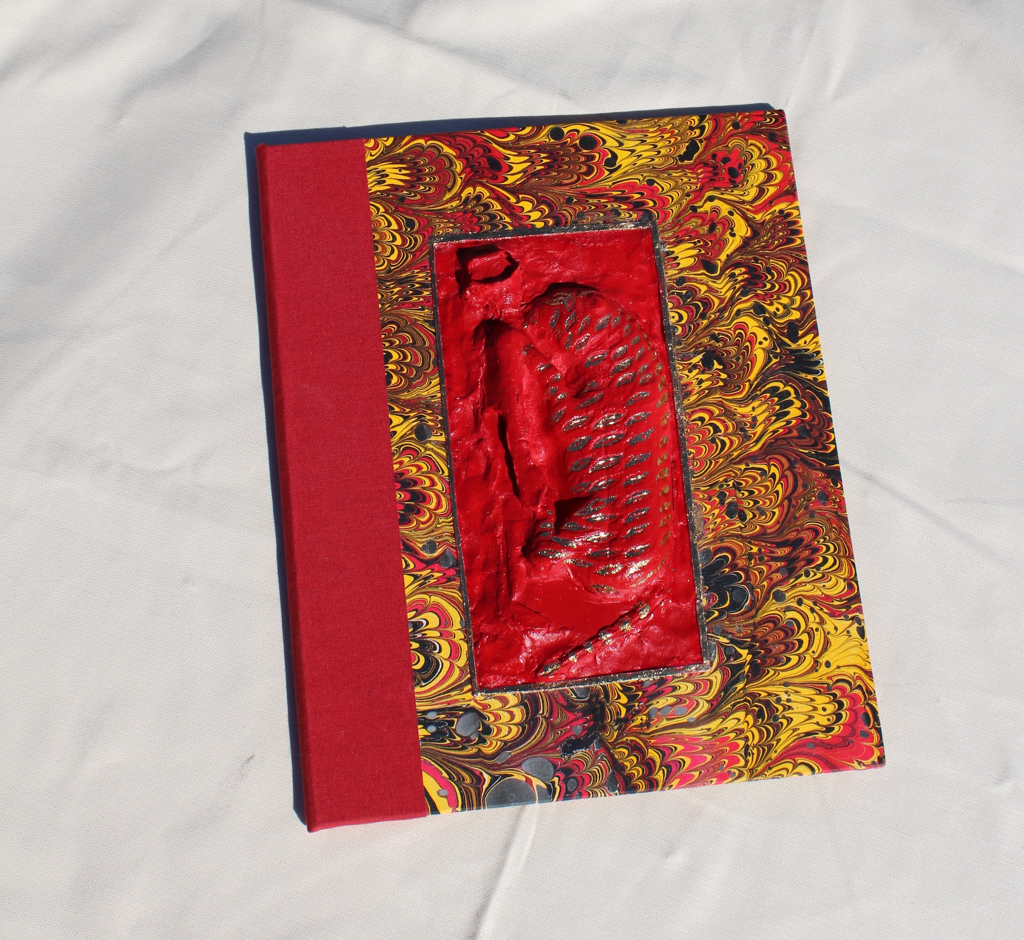 a marbled book cover with a statue molded on the cover of a tiger eating a man